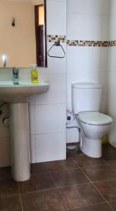 La salle de bains est pourvue de toilettes et d'un lavabo. dans l'établissement Apartment in a Gated Community, à Arusha