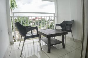 two black chairs and a table on a balcony at HOTEL LETS STAY in Cochin