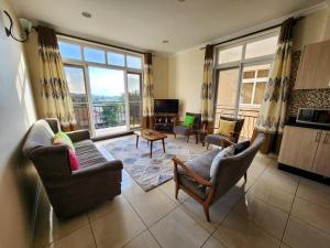 - un salon avec des chaises et une grande fenêtre dans l'établissement Apartment in a Gated Community, à Arusha