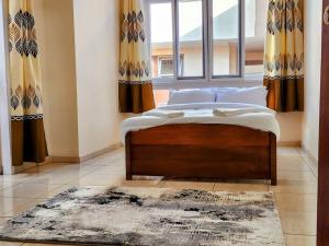 Ce lit se trouve dans un dortoir doté d'une fenêtre et d'un tapis. dans l'établissement Apartment in a Gated Community, à Arusha