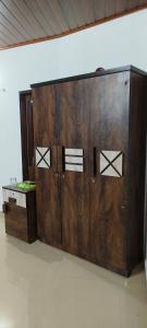 a pair of wooden doors in a room at Prakruthi home stay in Mangalore