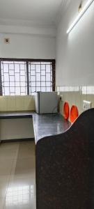 an empty room with two orange benches in it at Prakruthi home stay in Mangalore