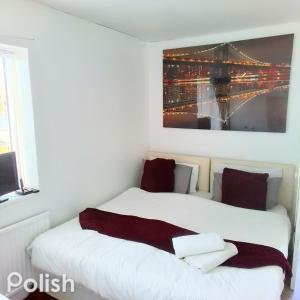 two beds in a room with a picture on the wall at Tsalach Short Lets in Nottingham