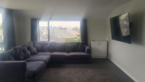 uma sala de estar com um sofá e uma grande janela em Infinity Dreams em Richmond
