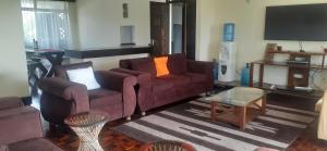sala de estar con 2 sofás y TV en Coral Luxury homestay nyali-on coral drive, en Mombasa