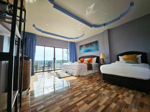 um quarto com 2 camas e uma grande janela em So View Phuket Resort em Ban Sam Kong