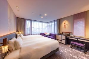 a hotel room with a large bed and a desk at Miyako City Kintetsu Kyoto Station in Kyoto