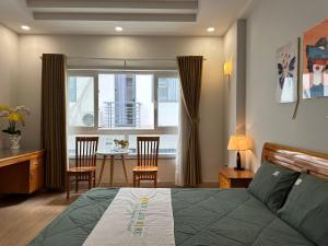 a bedroom with a bed and a table with chairs at NEW LAND Apartment 2 - Phu My Hung in Ho Chi Minh City