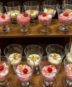 a group of glasses filled with desserts on a shelf at Fiyavalhu Resort Maldives in Mandhoo