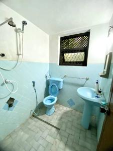 a bathroom with a blue toilet and a sink at Kaaya Villa @ Thalawathugoda in Colombo