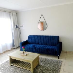 ein blaues Sofa im Wohnzimmer mit Couchtisch in der Unterkunft 43 Home self Catering with backup power in Witbank