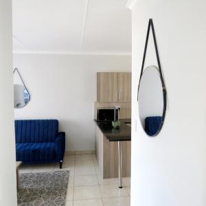 a living room with a blue couch and a mirror at 43 Home self Catering with backup power in eMalahleni