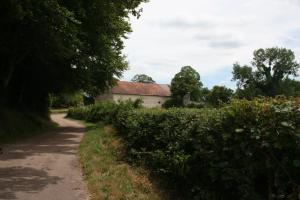 a dirt road next to a building with a house at Champ de la Fontaine in Brassy
