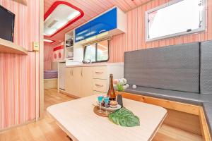 a living room with a table in front of a tv at Gangneung C-cloud caravan in Gangneung