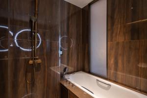 un bagno con doccia, lavandino e specchio di Echeng Hotel - Huawei Base Store in Shenzhen a Shenzhen