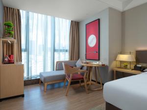 una camera d'albergo con un letto, un divano e un tavolo di Echeng Hotel - Huawei Base Store in Shenzhen a Shenzhen