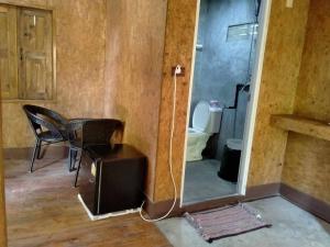 a room with a bathroom with a toilet and a mirror at Sukanyawoodhouse in Ban Tha Rua