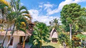 a house with palm trees in front of it at Garden View Ubud in Ubud