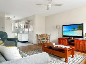 a living room with a couch and a tv at Northward Unit 1 1 2 Magnus St Nelson Bay in Nelson Bay