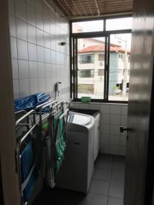 uma casa de banho com um lavatório e uma máquina de lavar roupa em Apartamento Rafaelli em Florianópolis