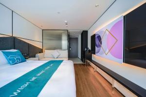 - une chambre avec un grand lit et un mur dans l'établissement Pengke Boutique Hotel - Sungang Sunway Station, à Shenzhen