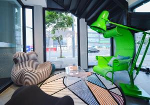 a living room with a green lamp and a chair at Pengke Boutique Hotel - Sungang Sunway Station in Shenzhen