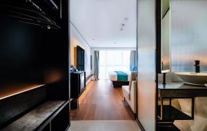 una camera d'albergo con letto e lavandino di Pengke Boutique Hotel - Sungang Sunway Station a Shenzhen