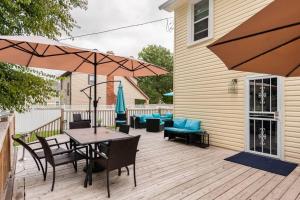 een houten terras met een tafel, stoelen en parasols bij 3 bed/5 bath Small Party Space & Deck Smoking OK in Detroit