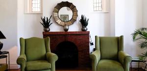 two green chairs in a living room with a fireplace at Gardens Retreat in Cape Town
