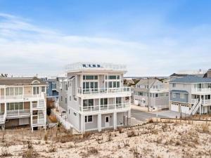 - un grand bâtiment blanc sur la plage avec des maisons dans l'établissement New Oceanfront In Peahala Park , Sleeps 11 ,, à Brant Beach