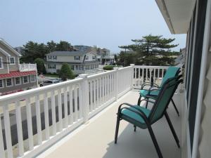 two chairs on a balcony with a view of a street at Immaculate 2Nd Floor Duplex In Brant Beach Located Just 3 Homes From The Beach in Brant Beach