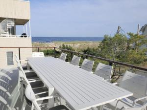 een tafel en stoelen op een balkon met uitzicht op de oceaan bij 3022 Casciaro in Harvey Cedars