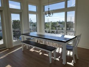 een eetkamer met een tafel, stoelen en ramen bij 3022 Casciaro in Harvey Cedars