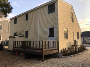 uma casa móvel com um alpendre e uma casa em Beachy Cape Cod Perfect For Families em Beach Haven