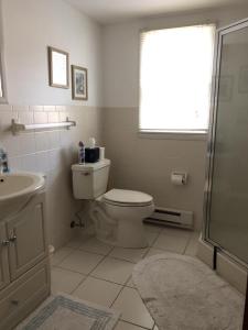 uma casa de banho branca com um WC e um lavatório em Beachy Cape Cod Perfect For Families em Beach Haven