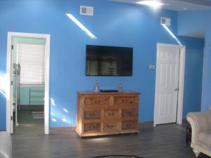un salon avec un mur bleu et une commode en bois dans l'établissement Super Cute!! Waterfront Lagoon In Beach Haven West!, à Manahawkin