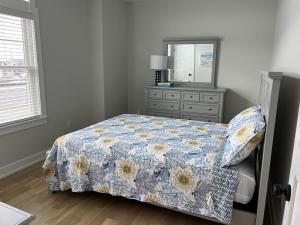 a bedroom with a bed with a dresser and a mirror at Tastefully Decorated Condo in Ship Bottom