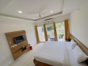 a bedroom with a large bed and a tv at HOTEL LETS STAY in Ernakulam