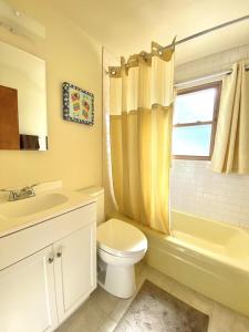 La salle de bains est pourvue d'un lavabo, de toilettes et d'une fenêtre. dans l'établissement Affordable Vacation Rental On Lbi, à Brighton Beach