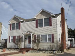 een wit huis met rode luiken bij Haven Beach Oceanside Home - Short Walk To The Beach! in Brant Beach