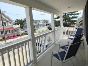 een veranda met 2 stoelen en uitzicht op een straat bij 1st Floor Duplex In Brant Beach Just 3 Homes From The Beach in Brant Beach