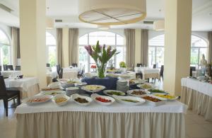 una mesa con muchos platos de comida. en Club Azzurro Hotel & Resort, en Porto Cesareo