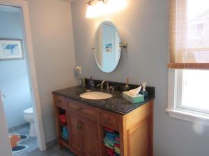 a bathroom with a sink and a mirror at Hear The Ocean From This Well Kept Oceanside Duplex in Brant Beach +9 photos
