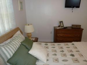 ein Schlafzimmer mit einem Bett, einer Kommode und einem Fernseher in der Unterkunft Oceanside 3 Bedroom, 1 Bath Duplex - A Short Walk To The Beach! in Beach Haven Crest