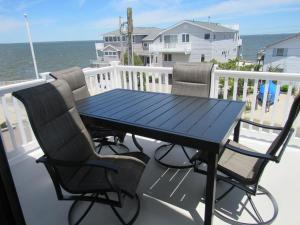 d'une table bleue et de chaises sur un balcon donnant sur l'océan. dans l'établissement Fritchman 3864, à Surf City