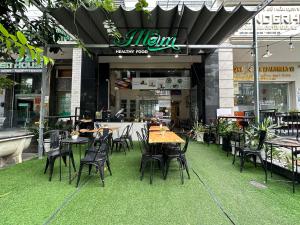a restaurant with tables and chairs in front of a building at NEW LAND Apartment 2 - Phu My Hung in Ho Chi Minh City