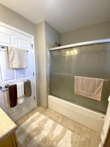 a bathroom with a shower and a bath tub with towels at Family Friendly Vacation Rental On Lbi in Beach Haven