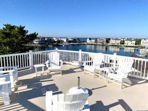 a group of white chairs on a deck overlooking a marina at Family Friendly Vacation Rental On Lbi in Beach Haven