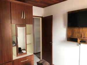 sala de estar con TV y espejo en Apartamento Rafaelli, en Florianópolis