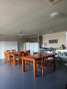 ein Esszimmer mit Holztischen und Holzstühlen in der Unterkunft Purple Hen Country Lodge in Katikati